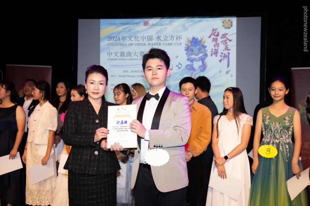 郑嘉辉在少年组比赛中夺冠， 新西兰华星艺术团团长/新西兰华夏文化艺术交流中心主席李芬为其颁奖